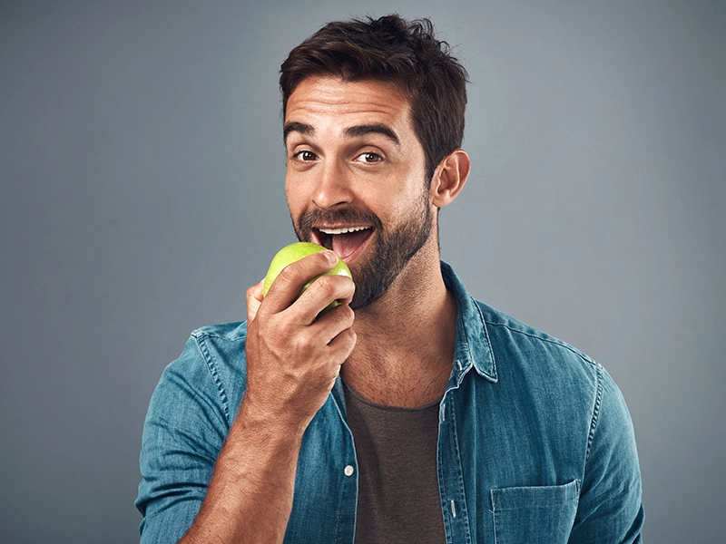 Un chico comiendo una manzana.