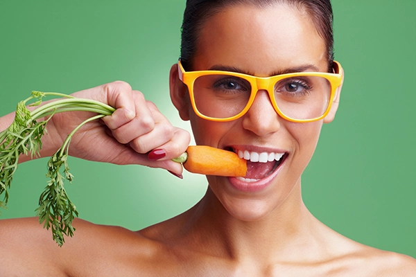 Una chica comiendo zanahoria.