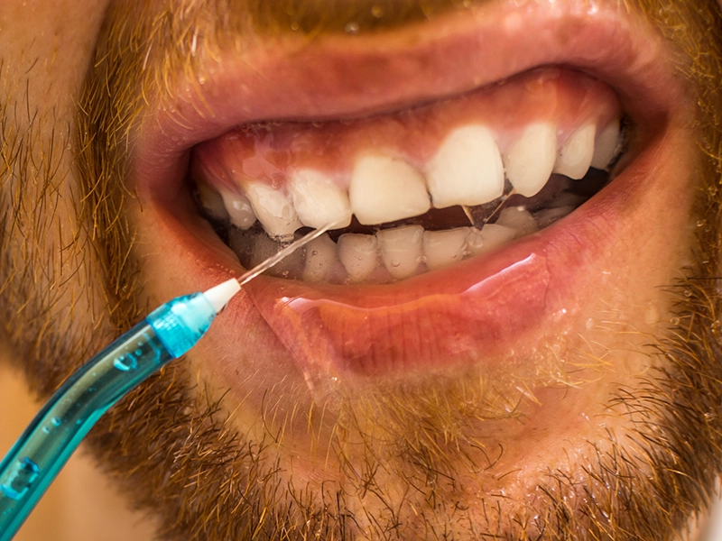 Un chico utilizando un irrigador dental.