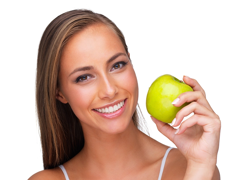 Una chica con una manzana en la mano.