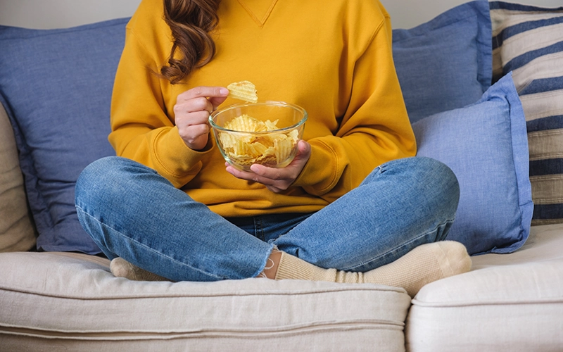 Una chica comiendo patatas fritas.