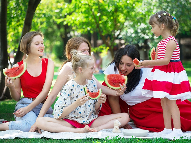 Una familia comiendo sandia, que es un snack saludable.